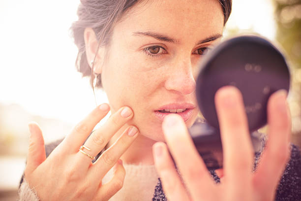 überprüfen meines looks in powder compact mirror - mirror women looking human face stock-fotos und bilder