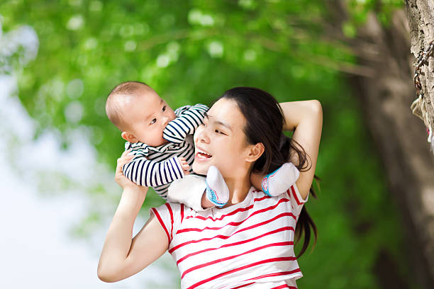istock Happy mother carrying baby on shoulders 590602424
