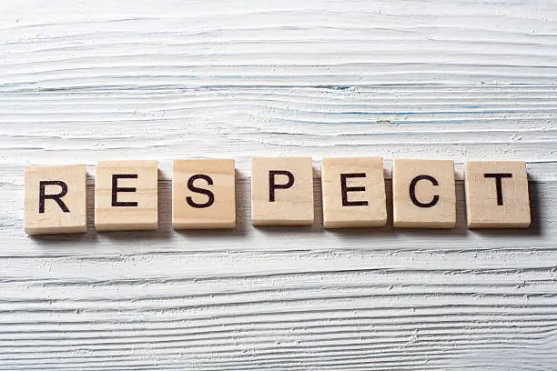 Photo of RESPECT word written on wood block ta wooden background