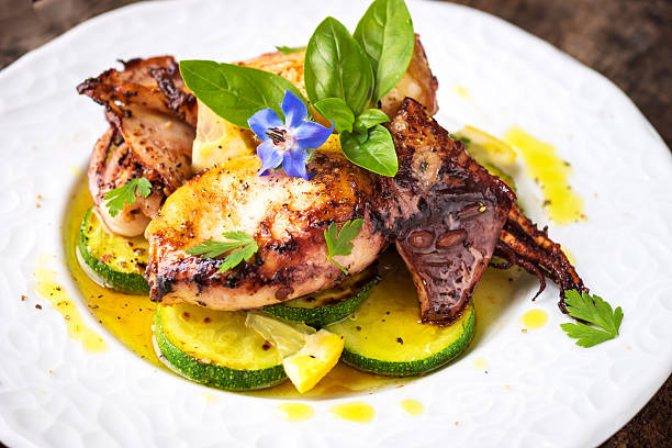 istock Grilled squid with lemon and zucchini on wooden background 590604834