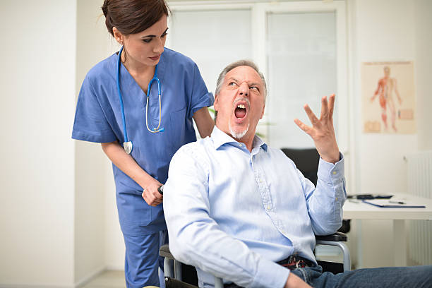 Angry disabled patient and a nurse Portrait of a disabled patient screaming to a nurse anger stock pictures, royalty-free photos & images