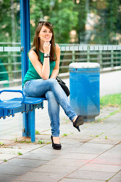 side view of young girl sitting on chair with stretched legs on white background