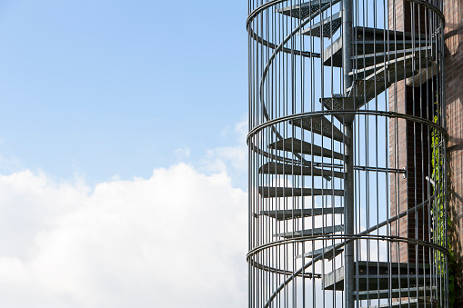Spiral emergency staircase with copy space in sky and clouds
