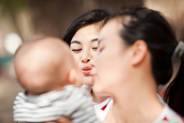 istock Young lesbian couple playing with baby 590611038
