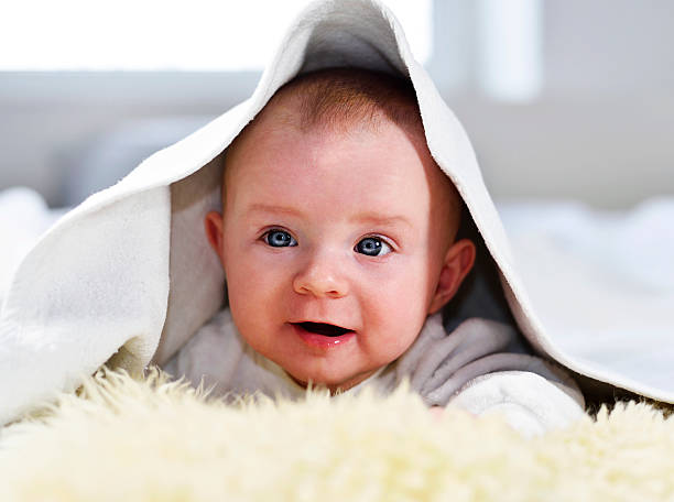 istock Cute baby under a baby blanket 590614608