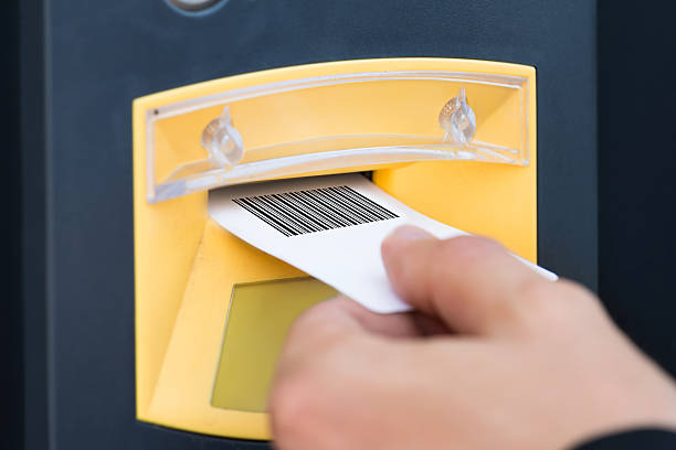 istock Person's Hand Inserting Ticket In Parking Slot 590615264
