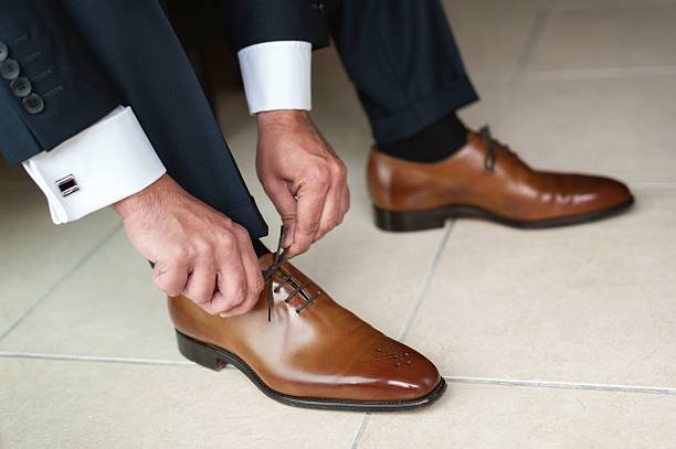 groom tying up shoes - dress shoe imagens e fotografias de stock