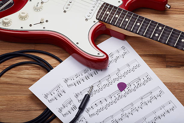 istock Red electric rock guitar with sheet music 590616102