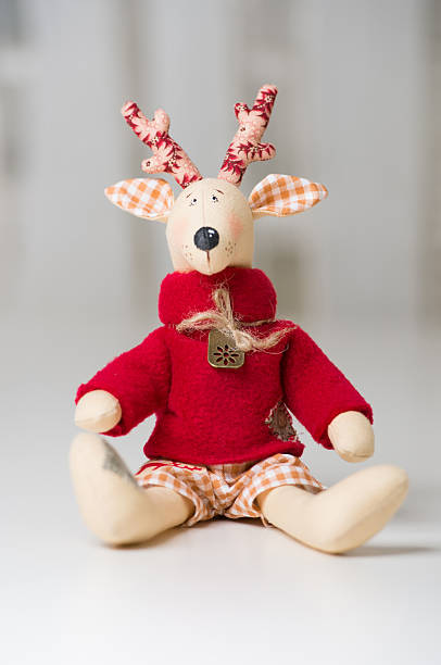 istock Handmade toy vintage Christmas reindeer sitting on light background 590616410