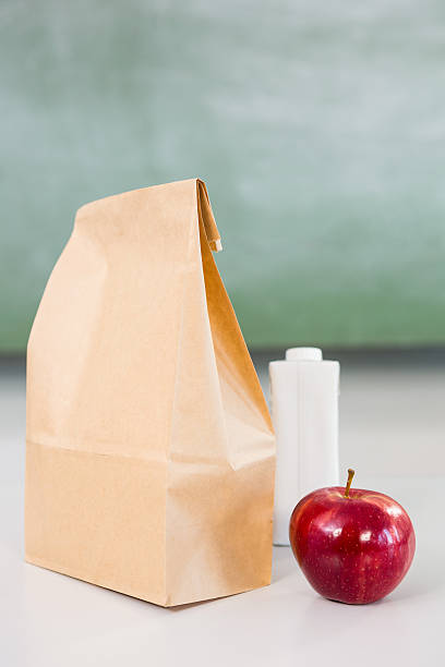 istock Apple with drink bottle and paper bag on table 590617792