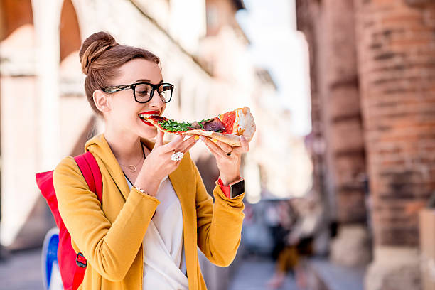 estudante com pizza perto da universidade na cidade de bolonha - arch top - fotografias e filmes do acervo