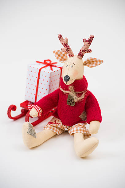 istock Handmade toy vintage Christmas deer sitting on light background 590619364