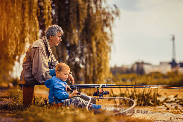 dziadek z wnukiem na wędkarstwo. - fishing rod fishing fishing reel casting zdjęcia i obrazy z banku zdjęć