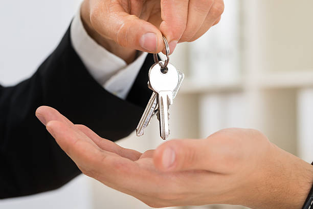 istock Person Hands Giving Key To Another Person 590622544