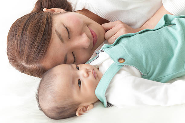istock Japanese mother lying with child 590622780