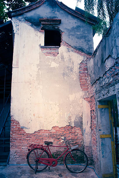 istock Old red bike and old cement wall with cracks. 590625582