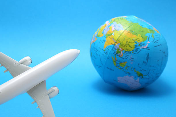 istock Miniature toy airplane and globe on blue background. 590625590