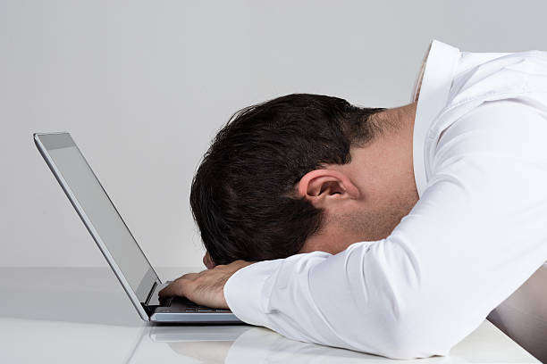 istock Stressed Businessman Leaning On Laptop At Desk 590626996