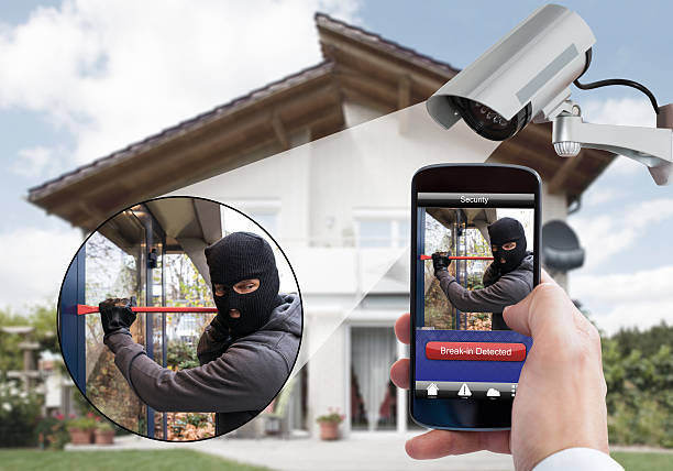 istock Person Hand Holding Mobile Phone Detecting Burglar 590627978