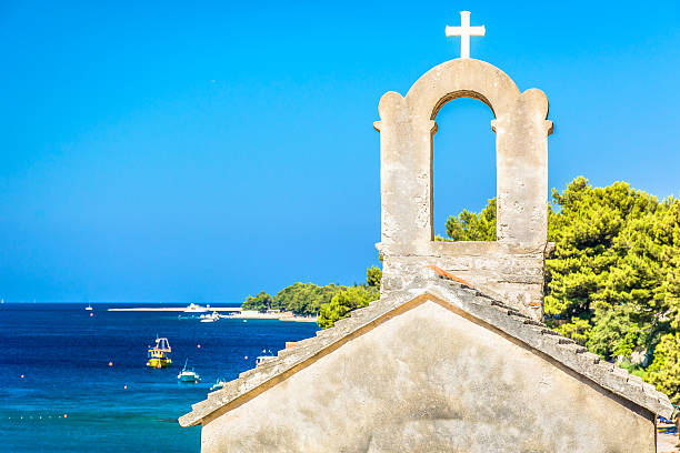 Island Brac Croatia. Small chapel with marble seascape and famous Golden Cape (Zlatni Rat) beach in background, Croatia summertime. old catholic church on island brac croatia stock pictures, royalty-free photos & images