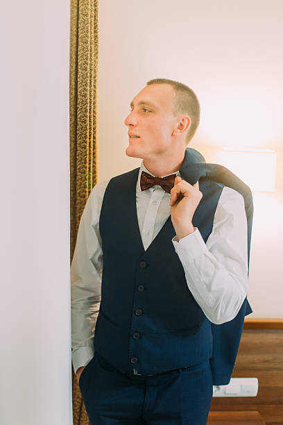 istock Handsome young athletic man dressed in blue suit posing indoor 591401304