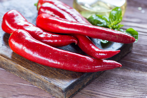 istock Red hot chili peppers on a wooden cutting board 591403352