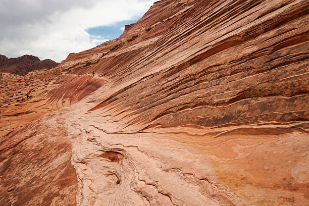 istock Lone hiker on red sandstone rocky path in Arizona 591404100