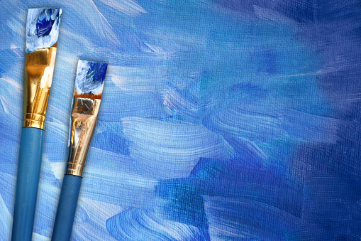 blue abstract painting with paint brushes