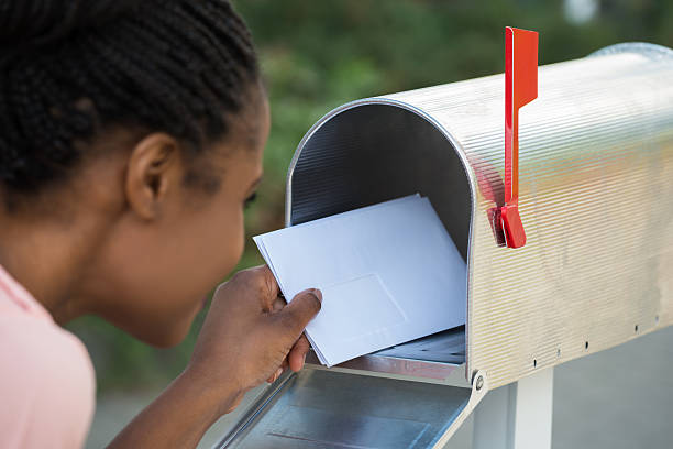 istock Woman Putting Letter In Mailbox 591406380