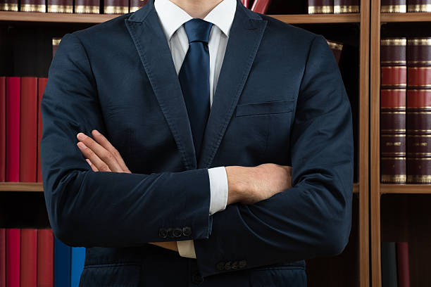 istock Midsection Of Lawyer Standing Against Bookshelf 591407570