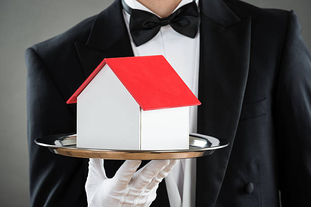 istock Midsection Of Waiter Holding House Model In Tray 591407928