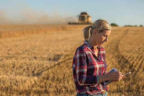 istock female farmer and combine harvester 591408678