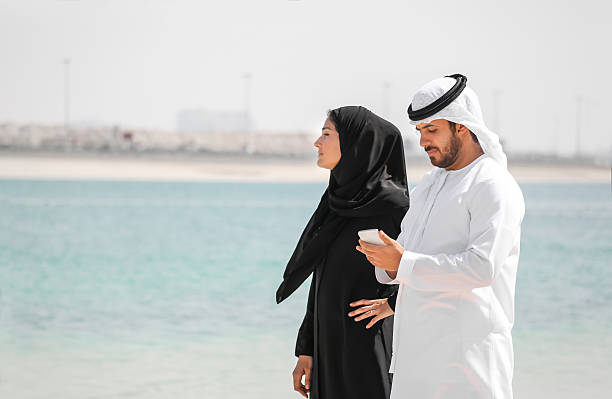 istock Arab couple with traditional wear on the beach 591408844