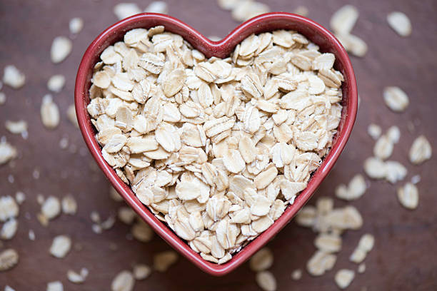avoine saine - oatmeal oat heart shape rolled oats photos et images de collection