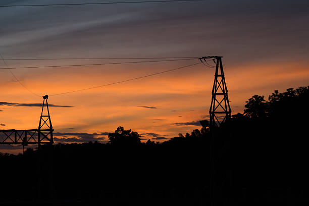 istock Silhouette of Electric Power Lines  at sunset 591410942