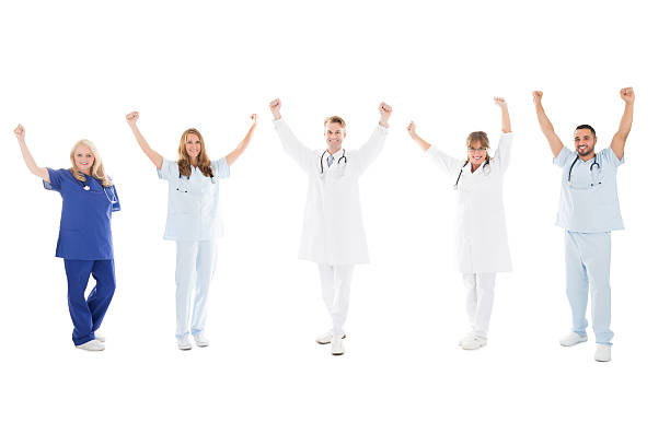 istock Happy Medical Team Standing With Arms Raised 591412804