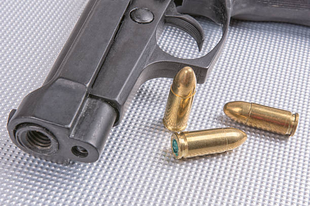 istock Bullets and gun on aluminium background 591413102