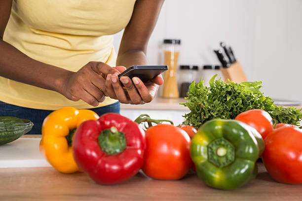 istock Close-up Of A Woman Using Mobile Phone In Kitchen 591413958