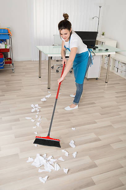 istock Female Janitor Sweeping Hardwood Floor 591415206