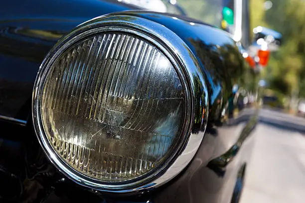 Detail of an attique car at a retro car parade. Headlights. Black headlamp.