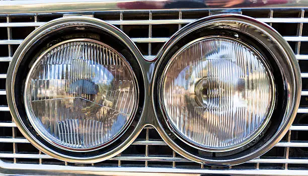 Detail of an attique car at a retro car parade. Two headlights. Headlamp.