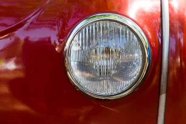 Detail of an attique car at a retro car parade. Headlights. Red headlamp.