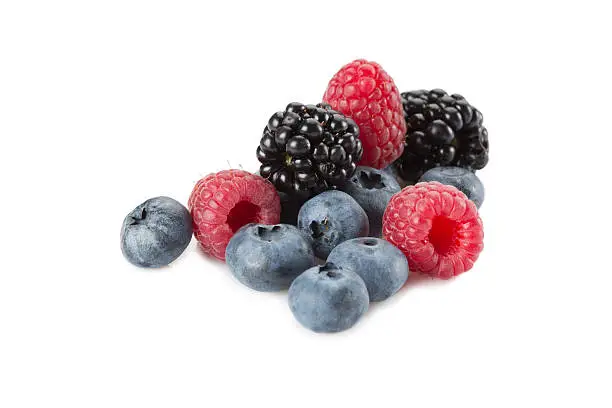 Mix of berries. Raspberries, blueberries and blackberries on a white background. Isolated.