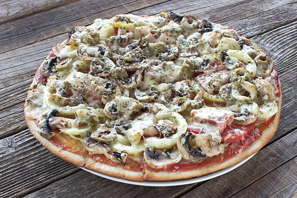 istock Whole pizza on wooden table 591420108