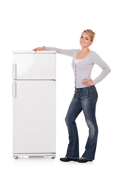 istock Woman Leaning On Refrigerator Over White Background 591420536