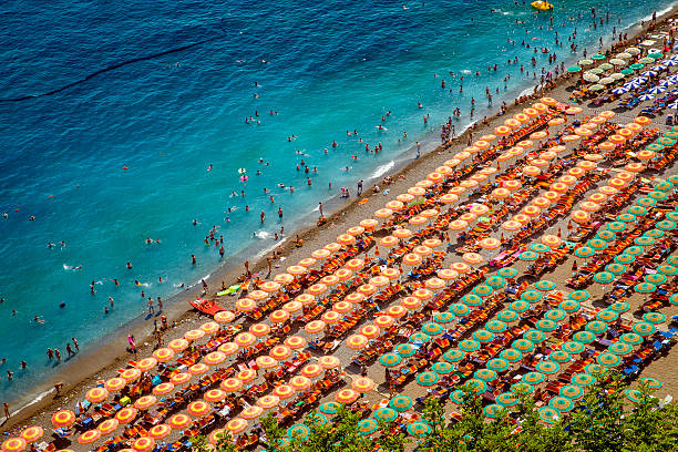 Aerial photo of tourists on a beach in Positano, Italy Aerial photography of tourists playing and taking sunbath on a sandy beach in Positano, Italy positano photos stock pictures, royalty-free photos & images