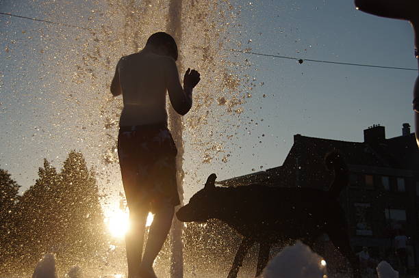 istock Playing in the city fountain 591424752