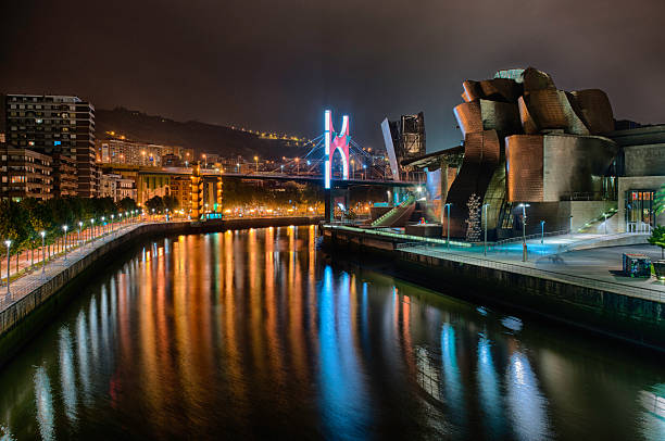 Bilbao, Spain - August 16, 2016: Guggenheim Museum and the estuary of Nervion river at night in downtown Bilbao, Spain.