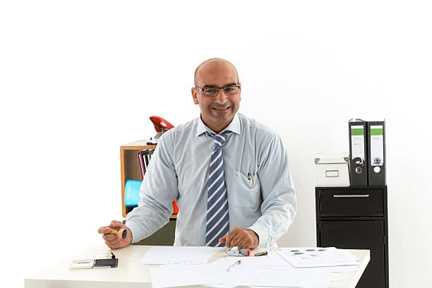 Bald office worker at desk looking laughing to the camera Bald office worker at desk looking laughing to the camera civil servant stock pictures, royalty-free photos & images