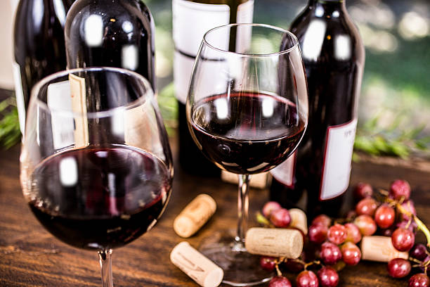 屋外ダイニングテーブルに赤ワインとブドウ。 - 赤ワイン ストックフォトと画像